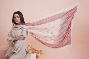 The Power of Dressing Well: How Fashion Reflects Confidence and Feminine Grace Woman in traditional attire with a scarf flowing elegantly indoors.